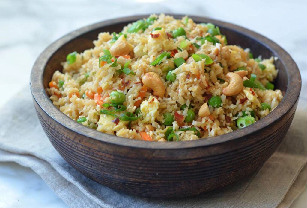 Bowl of couscous with broccoli and chickpeas on a textured background.