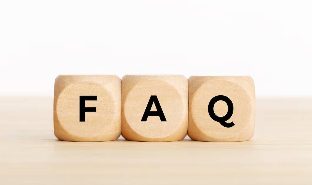 Three wooden blocks on a table spelling out FAQ.