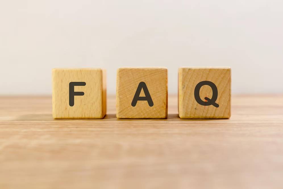 Three wooden blocks on a table spelling out FAQ.